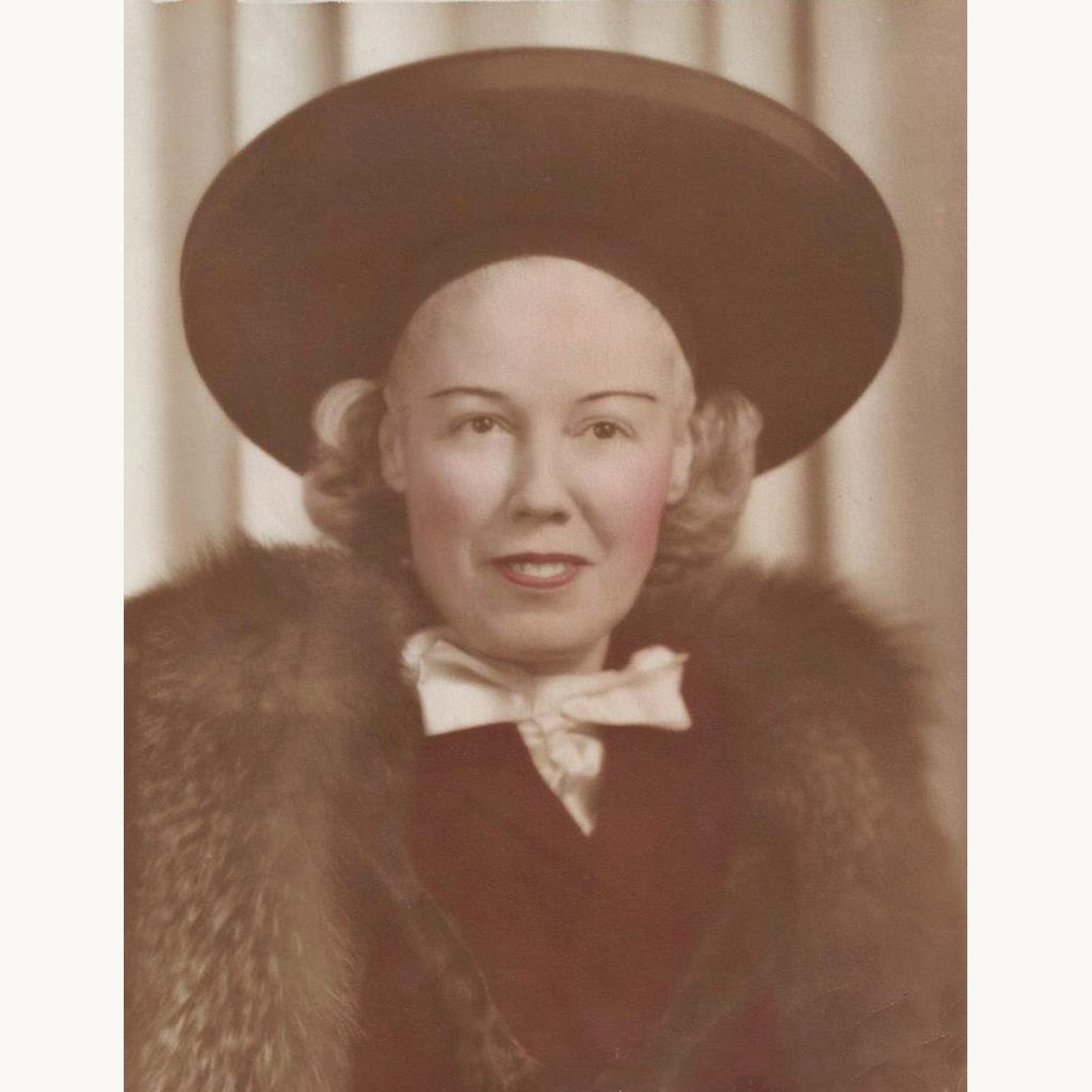 Aunt Julia in a hand-tinted studio portrait wearing a wide-brim hat and fur collar, early 1940s.