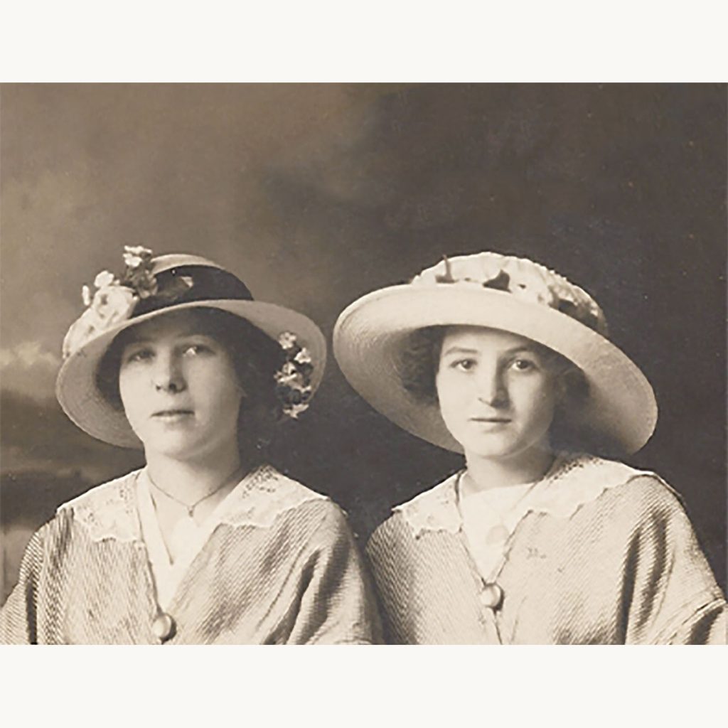 Two young women wearing Edwardian wide-brim hats and blouses, early 1900s.