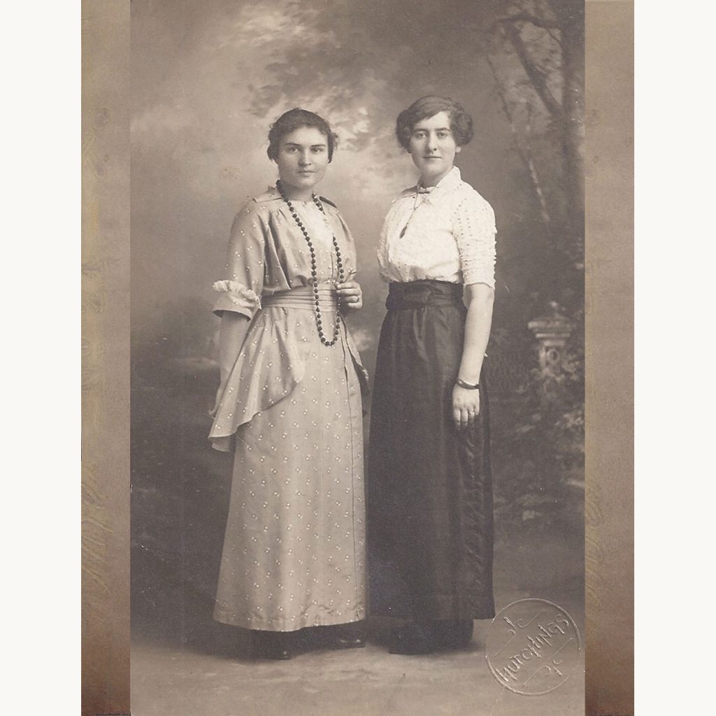 Madge at sixteen standing with another young woman, wearing early 20th-century dress, circa 1910.