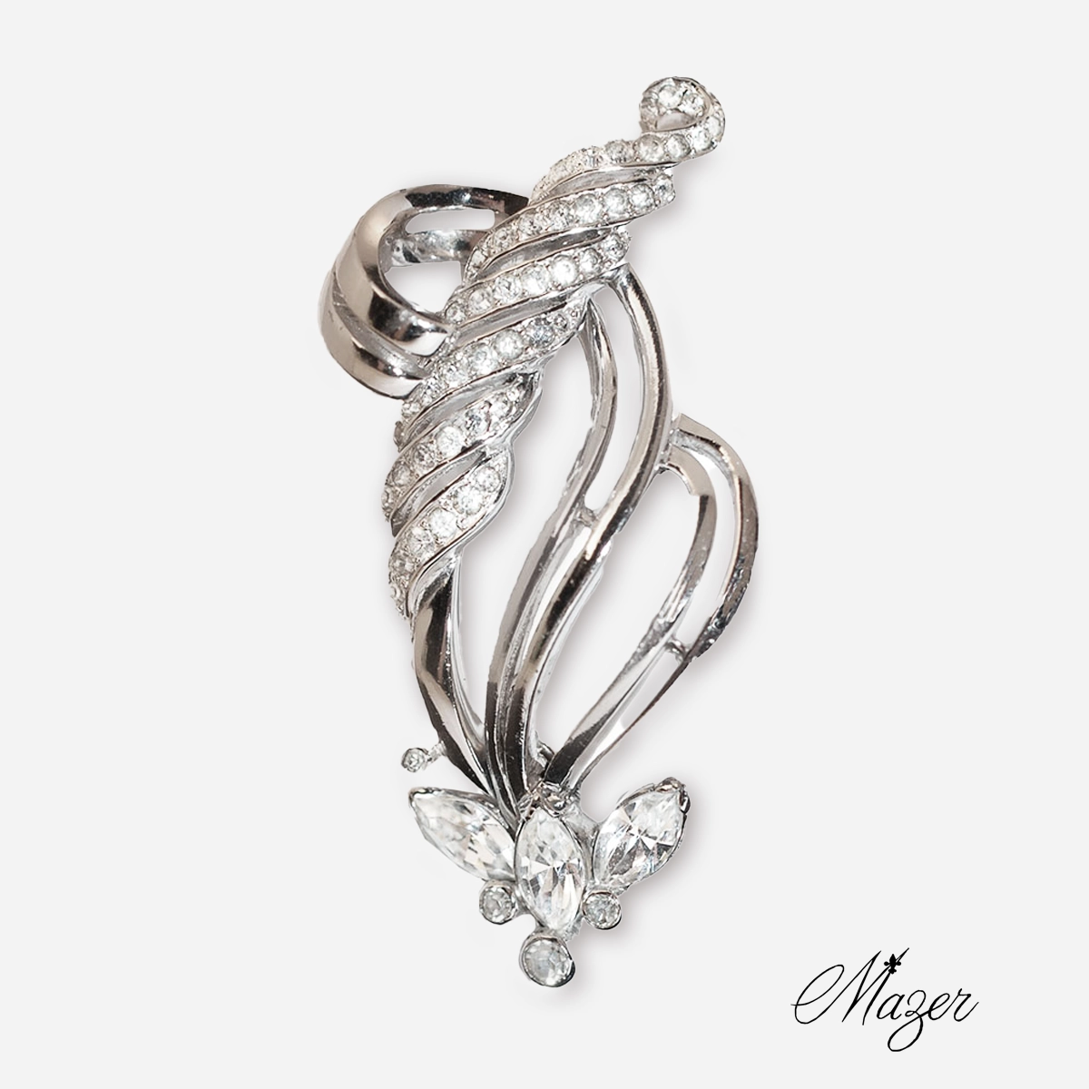 Close-up of vintage Mazer Bros silver rhinestone brooch with elegant swirl design and clear crystal accents, signed Mazer.