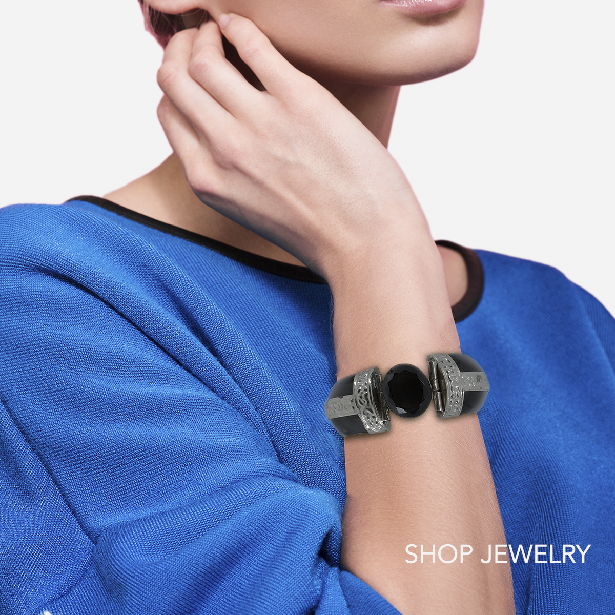 Shop vintage jewelry. Model in blue top wearing a black onyx clamper bracelet from India