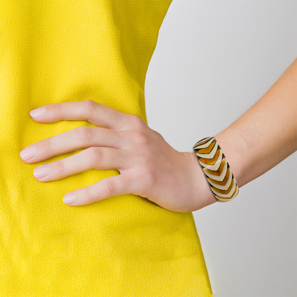 Woman in yellow, bright clothes on gray background. Hand on hips, vintage 60s stretch bracelet