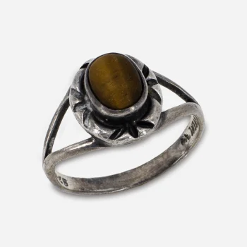 Close-up of warm golden-brown tiger’s eye stone with visible chatoyancy, bezel set in sterling silver.