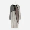 Flat lay on hanger: 1980s Steve Fabrikant color-block knit dress displayed on pearl hanger, gray background.