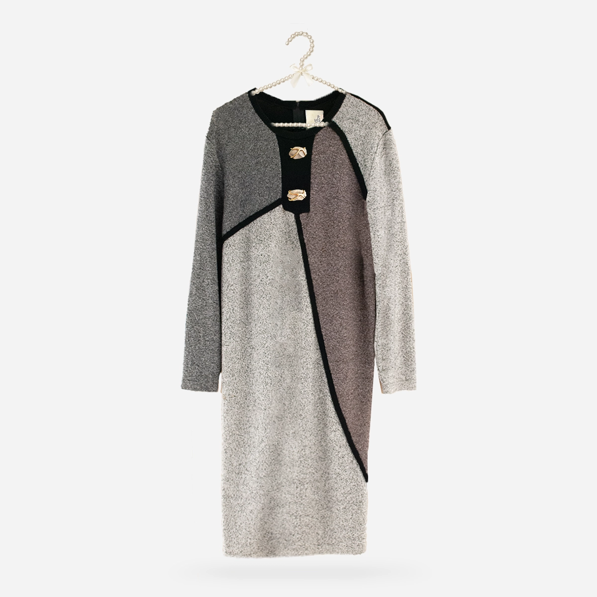 Flat lay on hanger: 1980s Steve Fabrikant color-block knit dress displayed on pearl hanger, gray background.