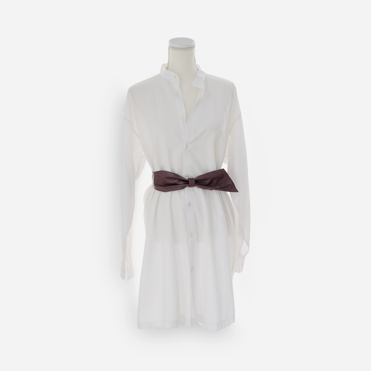 Purple leather bow belt styled over a white shirtdress.