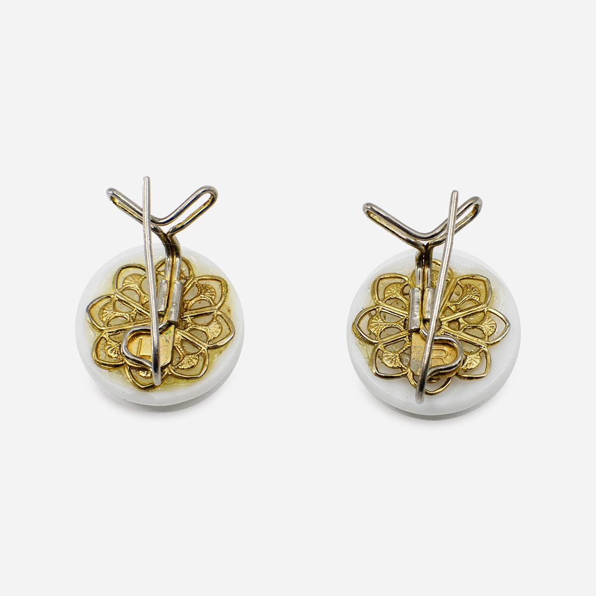 Back view of vintage white glass earrings showing gold floral clip design.