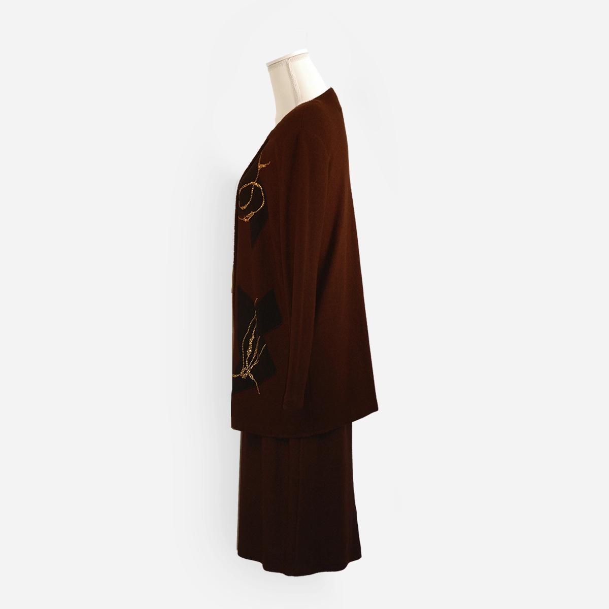 Side view of the Steve Fabrikant brown knit jacket showing the long silhouette and gold stud embellishment.