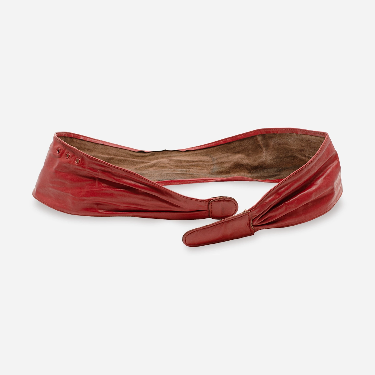 Angled view of red leather cinch belt highlighting interior suede lining and curved form.