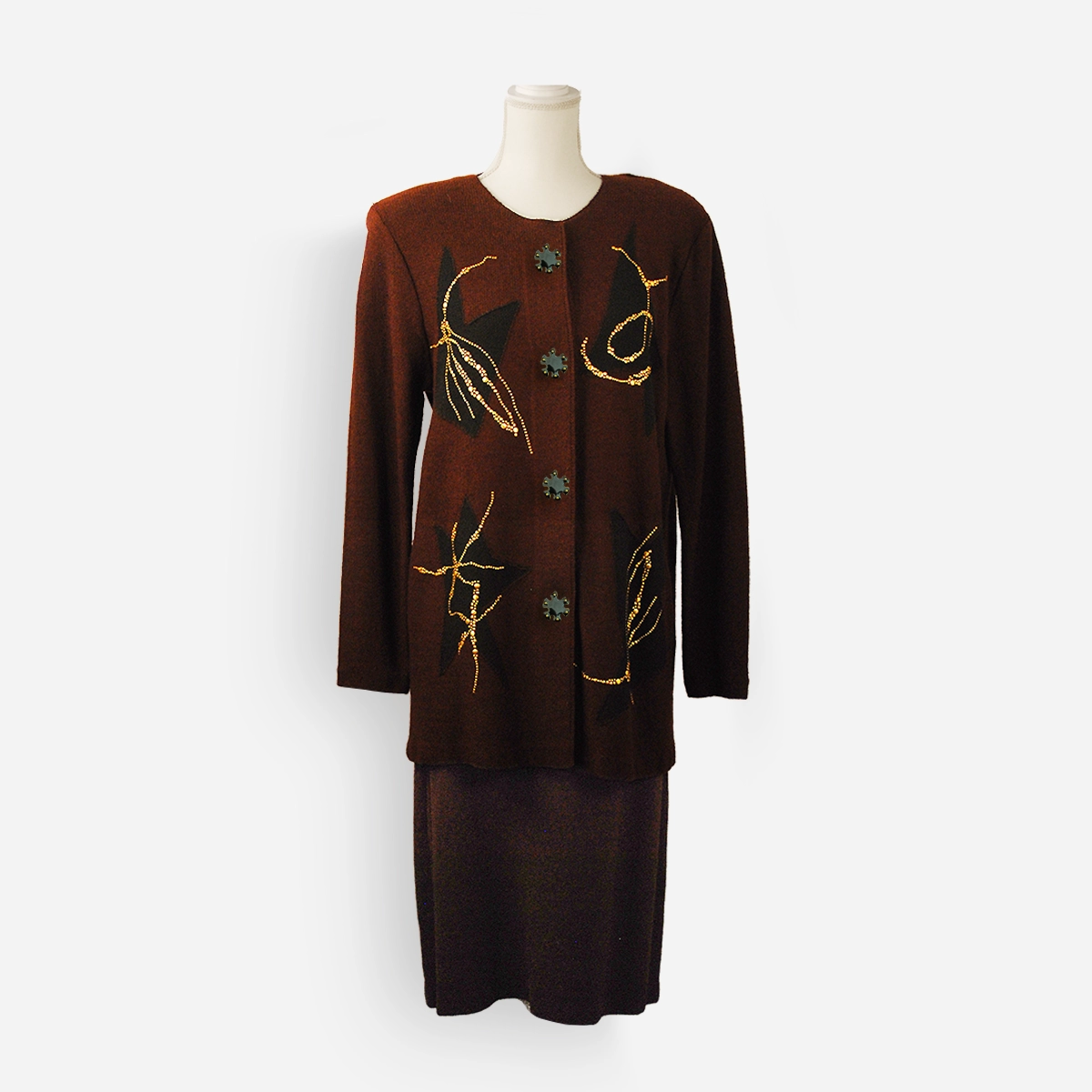 Front view of the Steve Fabrikant brown knit skirt suit on mannequin showing abstract black inserts and gold stud details.