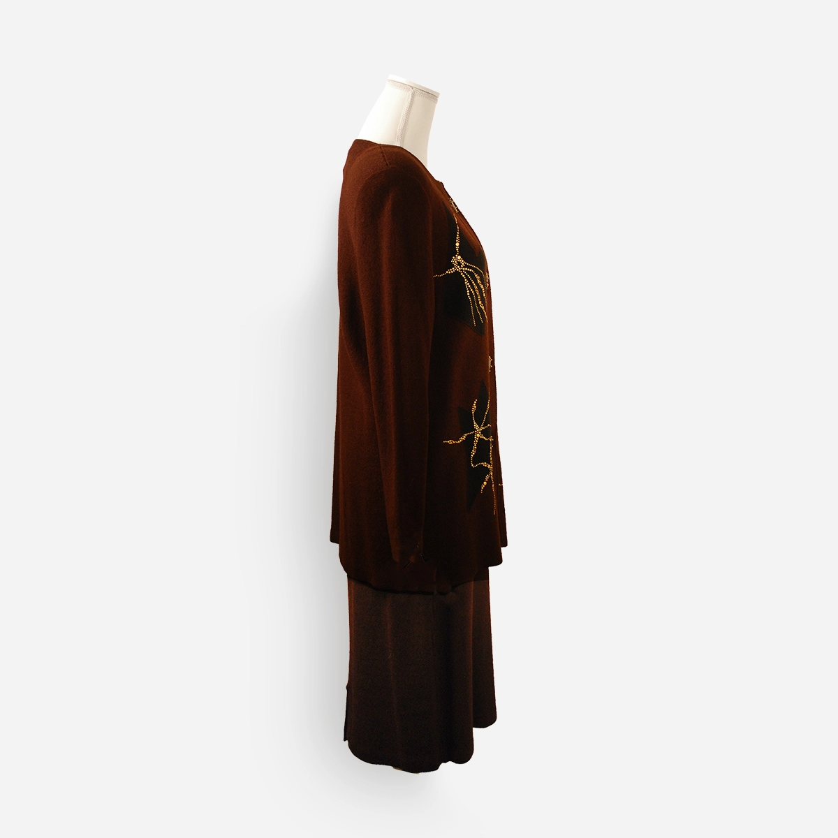 Side view of the brown knit Fabrikant jacket and skirt set showing drape and length.