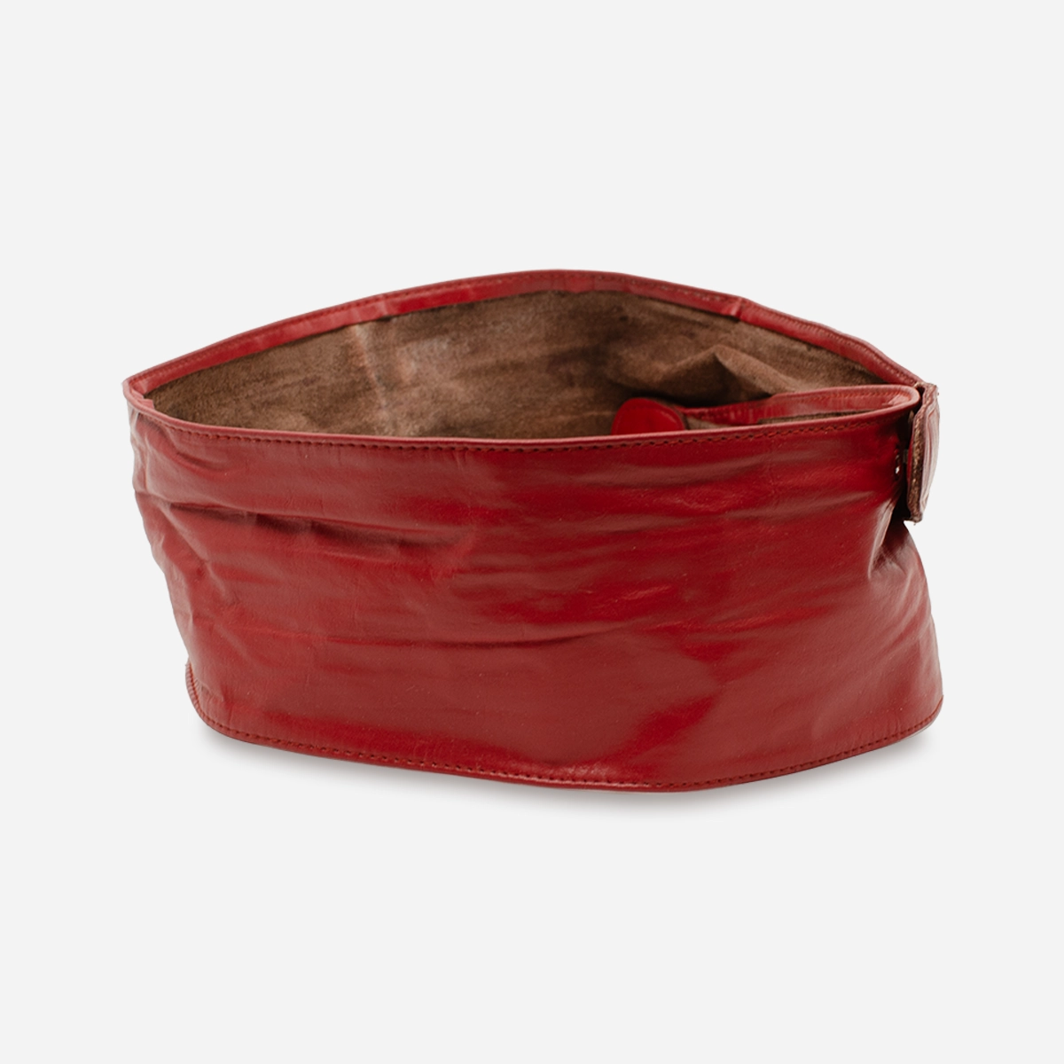 Side view of vintage red leather belt showing wide sculpted shape and soft leather texture.