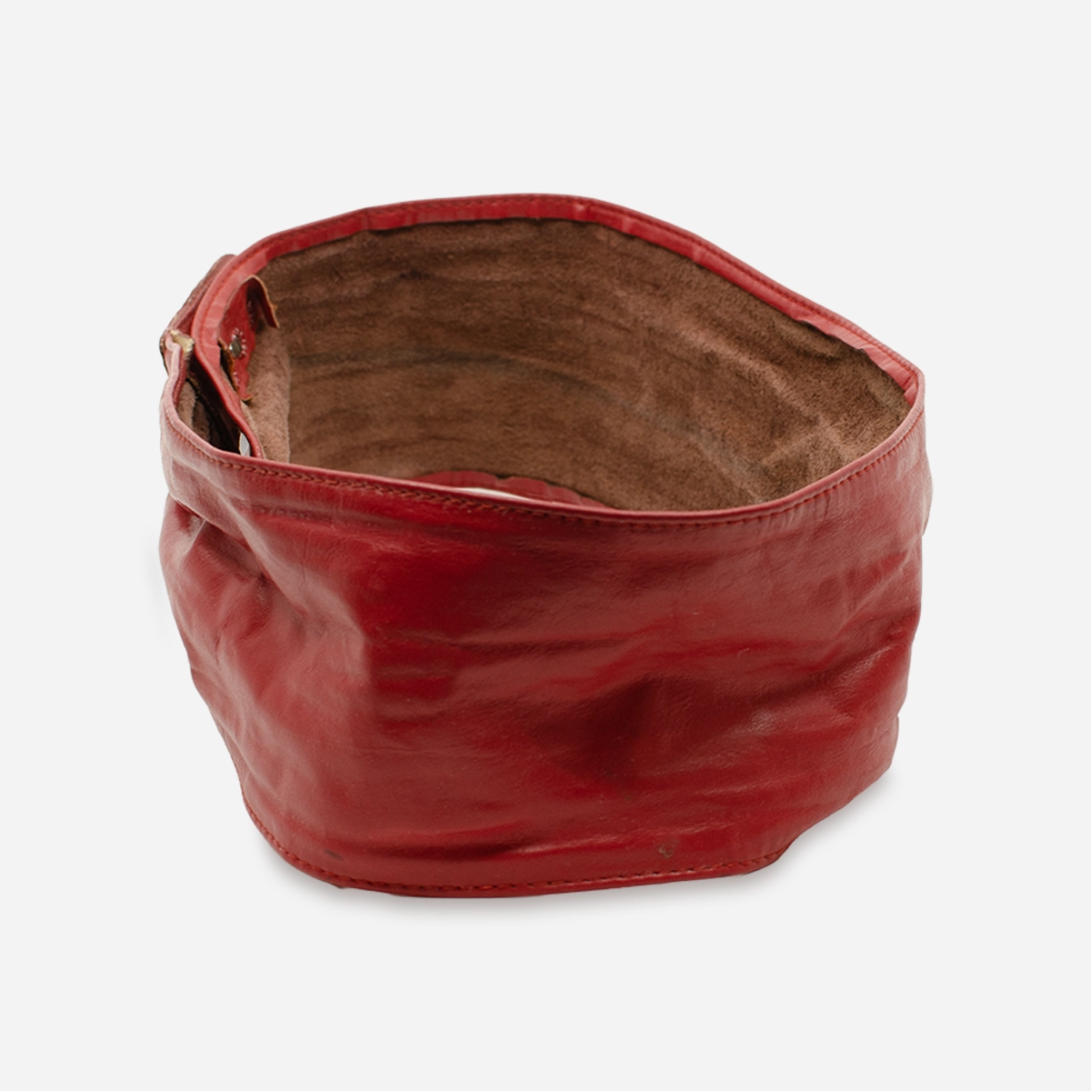 Side view of vintage red leather belt showing wide sculpted shape and soft leather texture.
