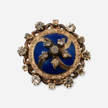 Antique blue enamel brooch with gold-tone die-stamped floral setting and paste stones.