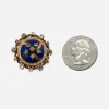Antique blue enamel brooch beside coin showing approximate 1 inch size