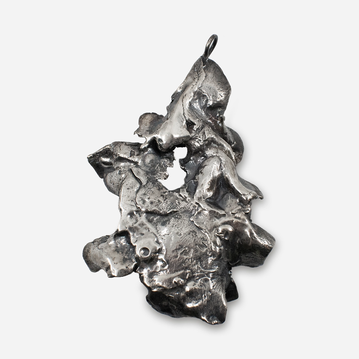 Back view of the Brutalist silver pendant showing textured free-form metalwork and sculptural surface details