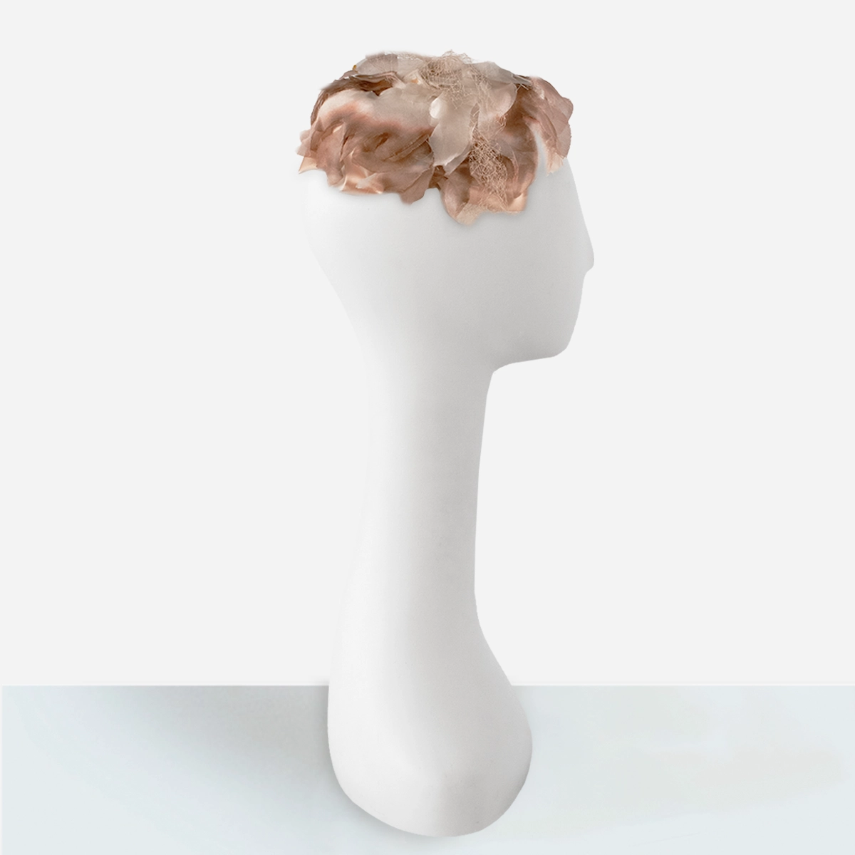 Side view of 1950s silk floral close hat with layered petals and veiling.