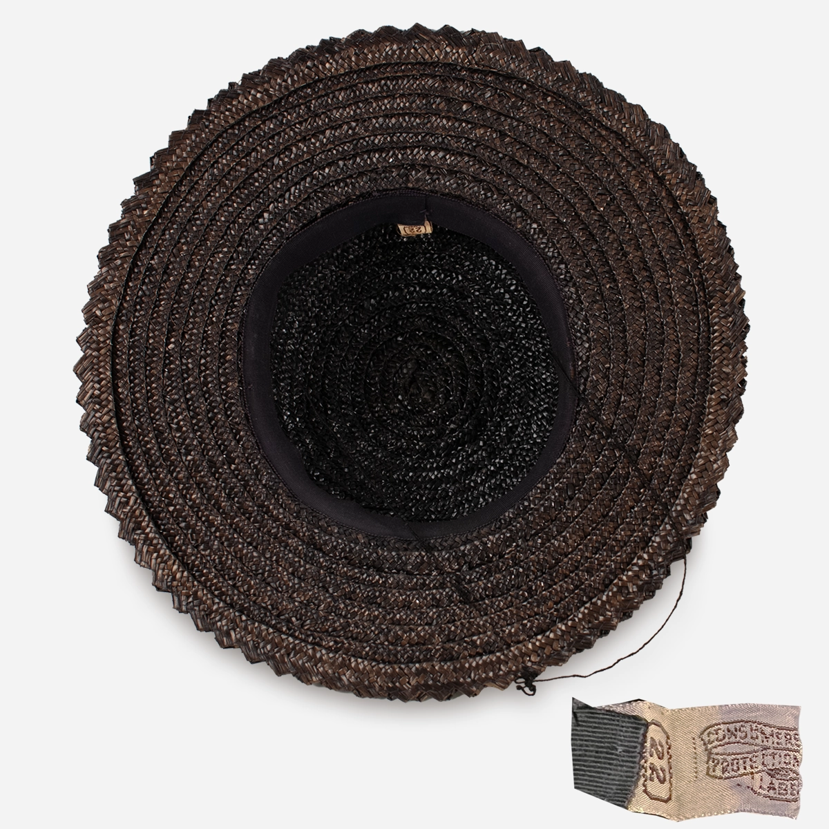 Interior view of vintage brown straw hat with original size 22 consumer protection label.