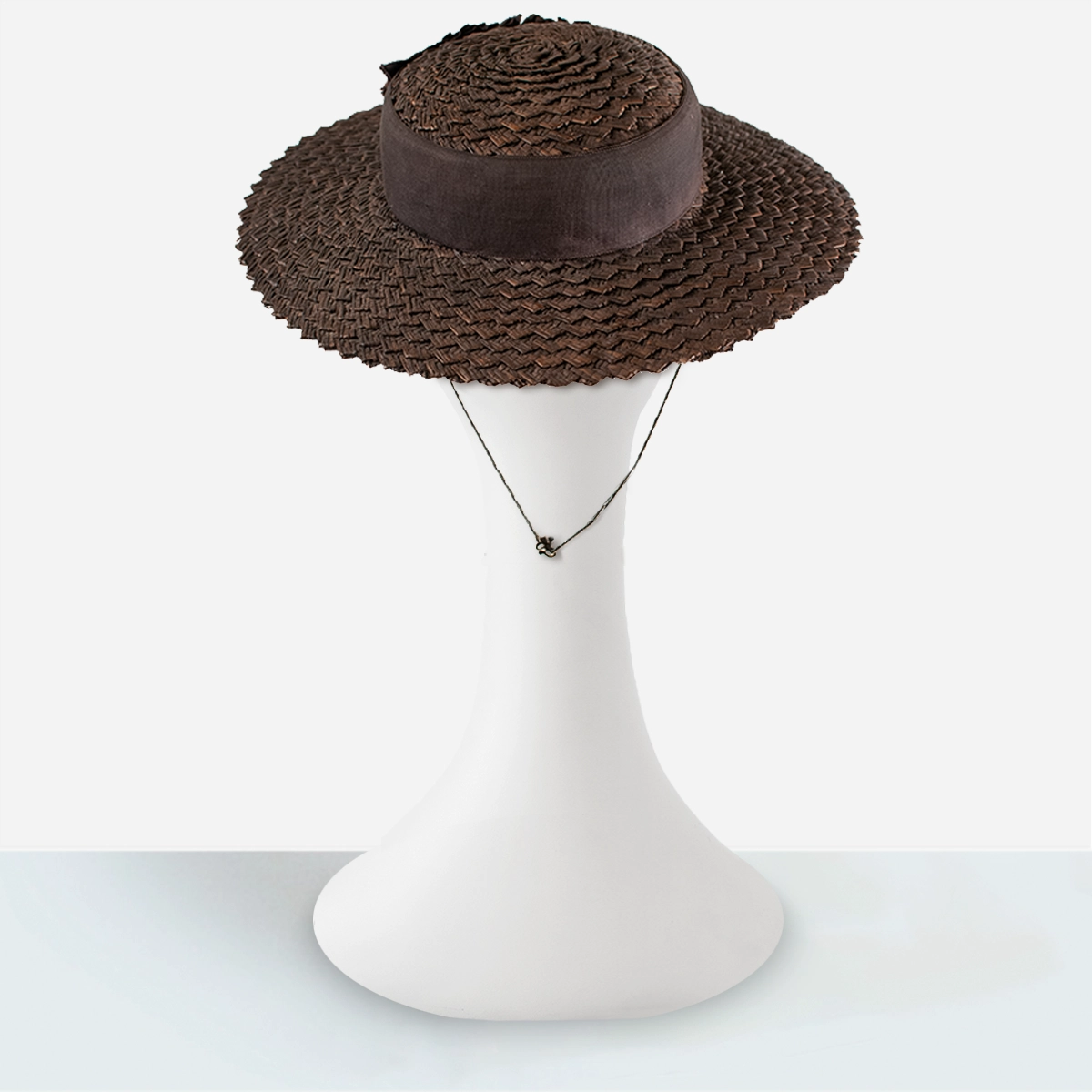 Back view of wide-brim 1930s brown straw hat with hat cord detail.
