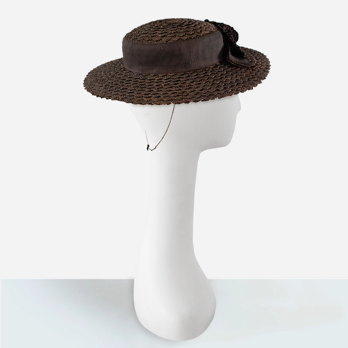 Side view of vintage 1930s brown straw hat with ruffled ribbon flowers