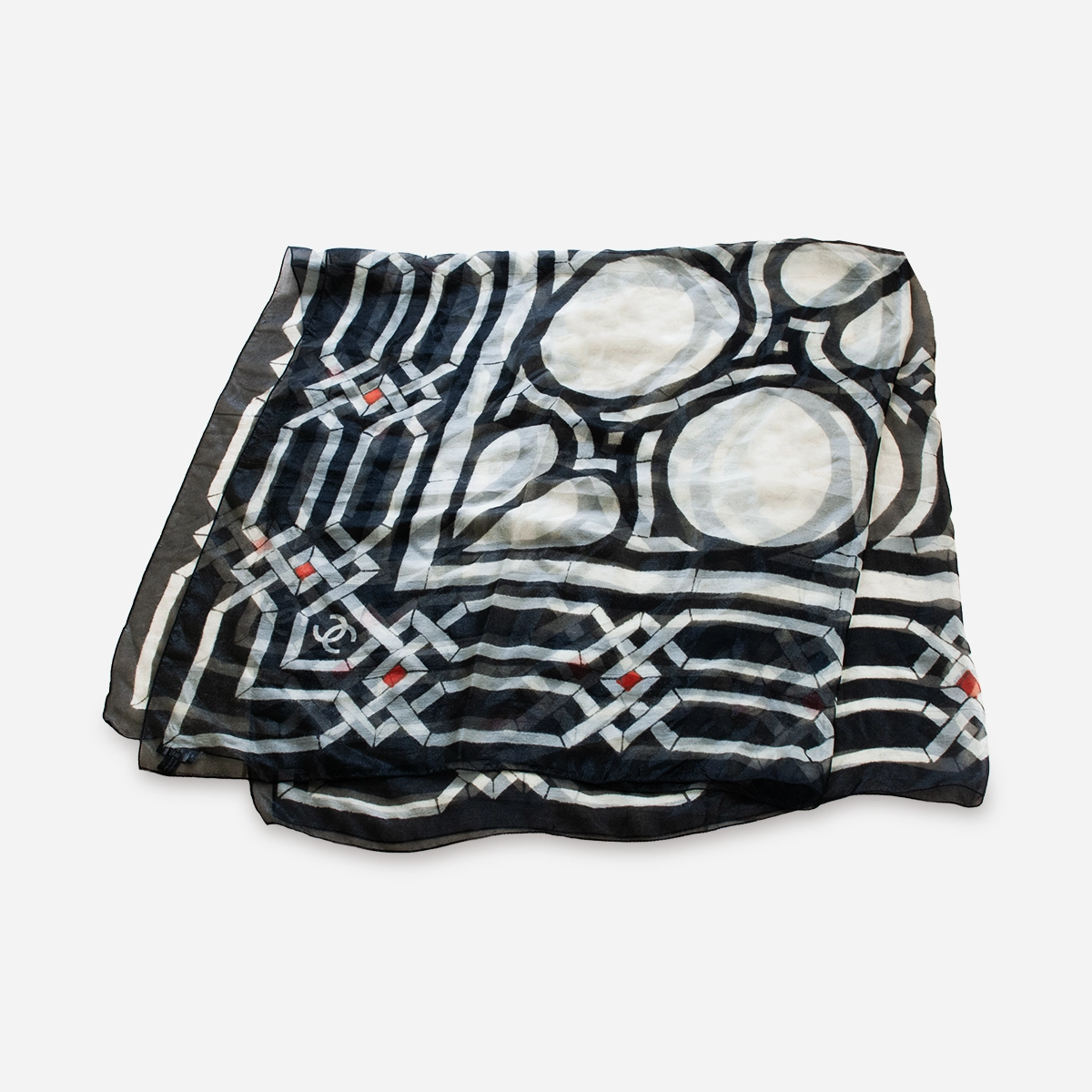Vintage chanel geometric scarf – shawl Flat lay of vintage Chanel silk scarf with cream, black, and red design.