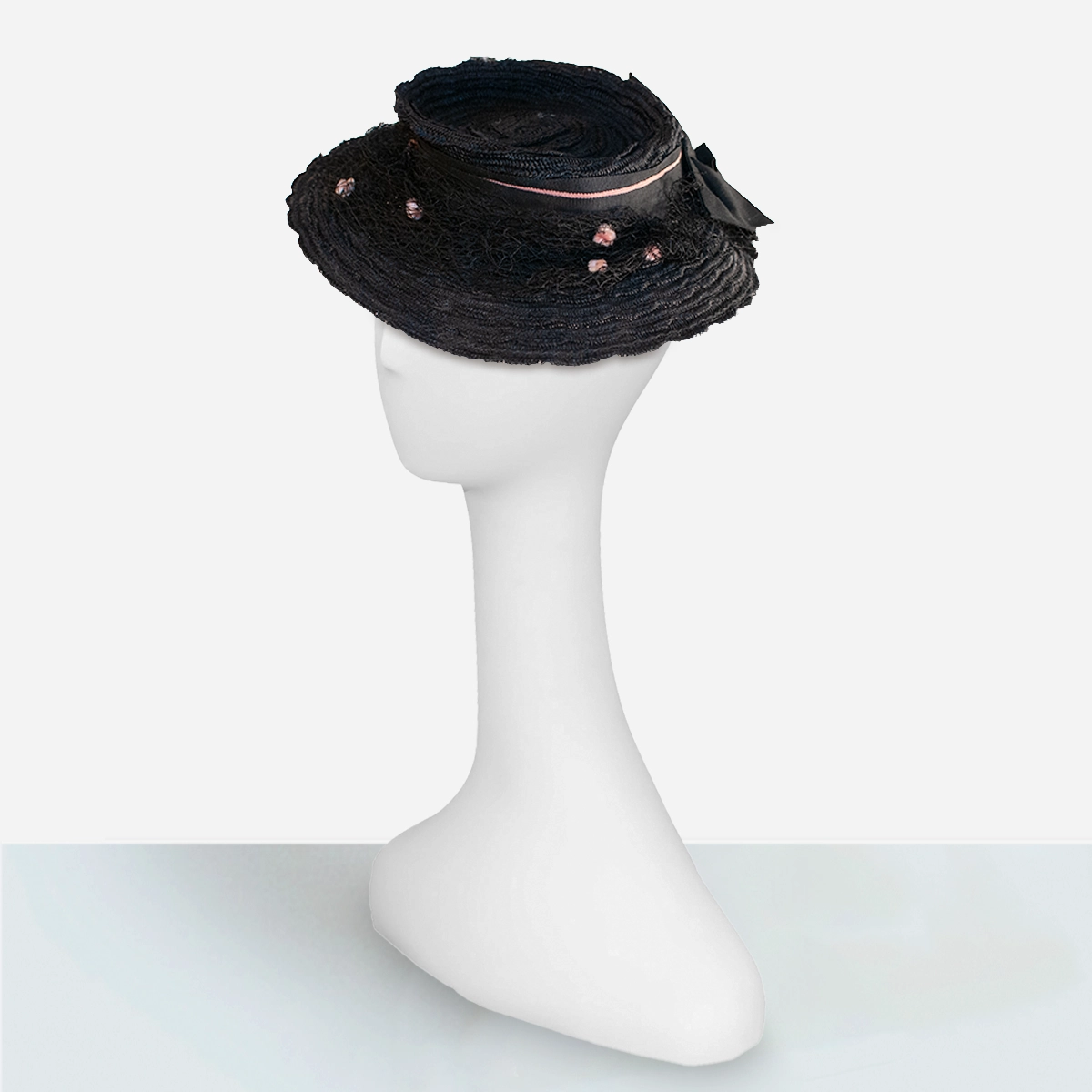 1930s black straw tilt hat modeled to show low-profile perched fit.