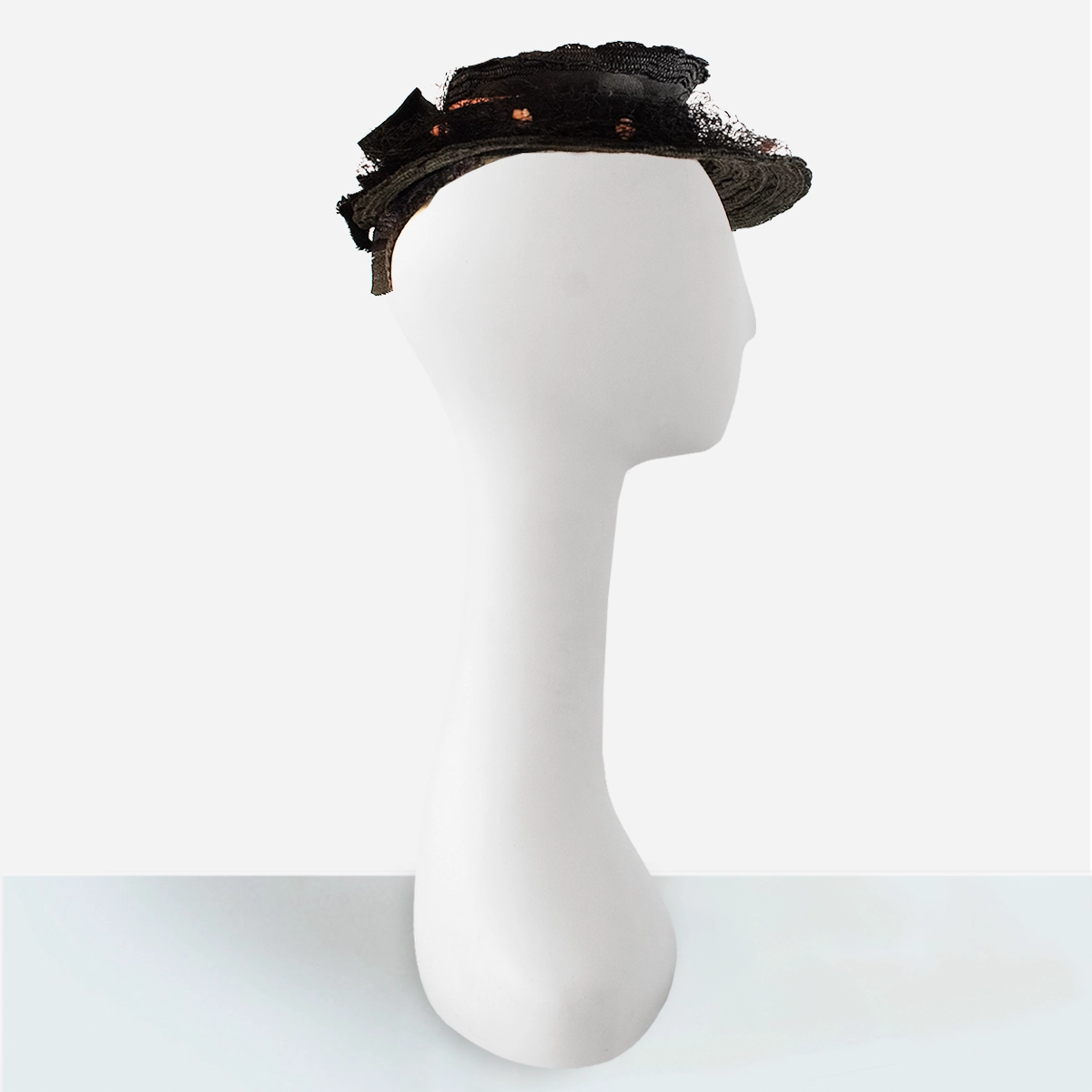 Angled view of vintage 1930s women’s black straw percher hat.