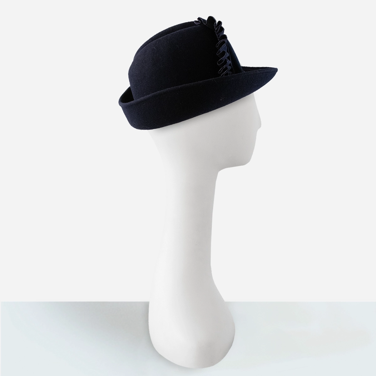 Early 1960s navy blue wool felt hat with upturned back brim, profile view.