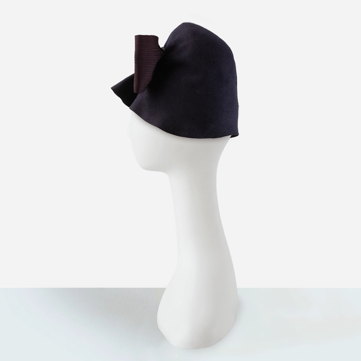 Side profile of 1950s draped cloche hat showing sculptural felt shaping