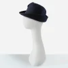 ruffled navy blue hat by sylvia Early 1960s navy blue sculptural felt hat with velvet ruffle trim, side view.