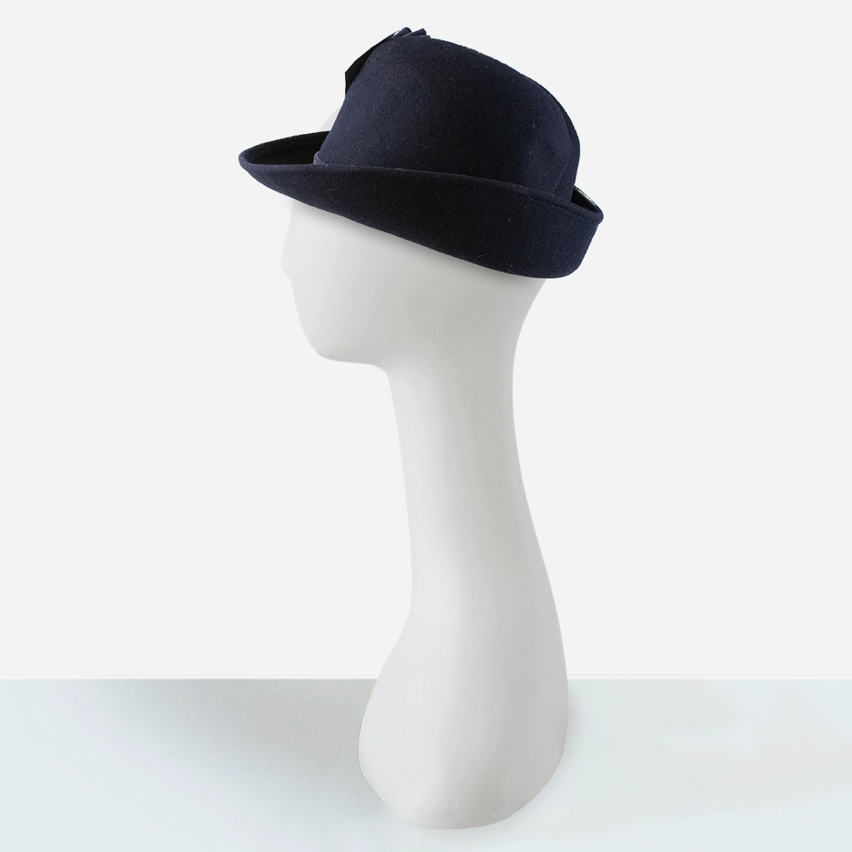 Early 1960s navy blue sculptural felt hat with velvet ruffle trim, side view.