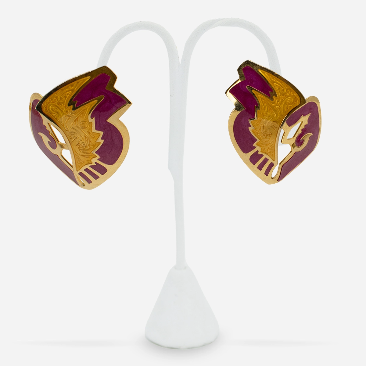 1980s abstract gold-tone earrings with glossy purple enamel detail on jewelry stand