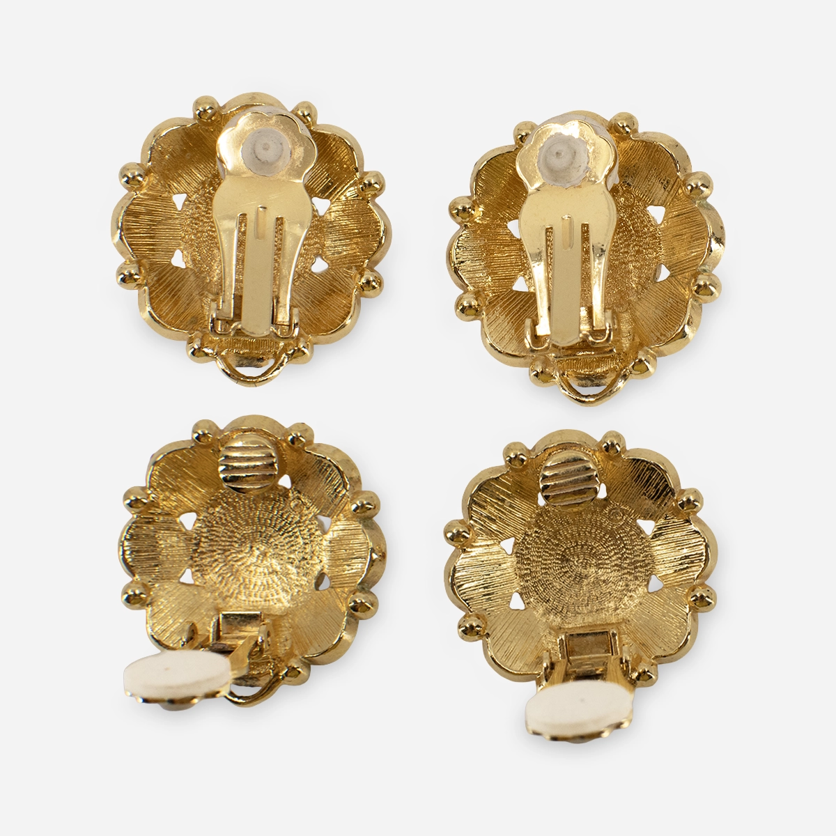 vintage avon gold enamel earrings Back of vintage Avon floral clip earrings showing gold tone clip backs and comfort pads.