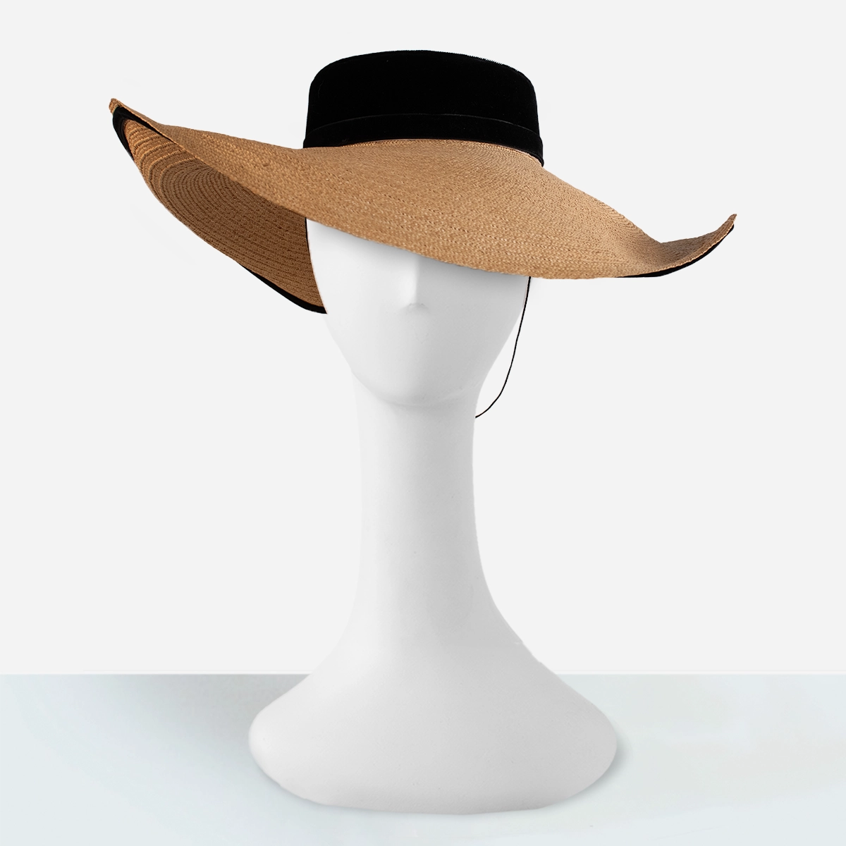 Vintage straw cartwheel hat with black velvet crown and wide brim on mannequin