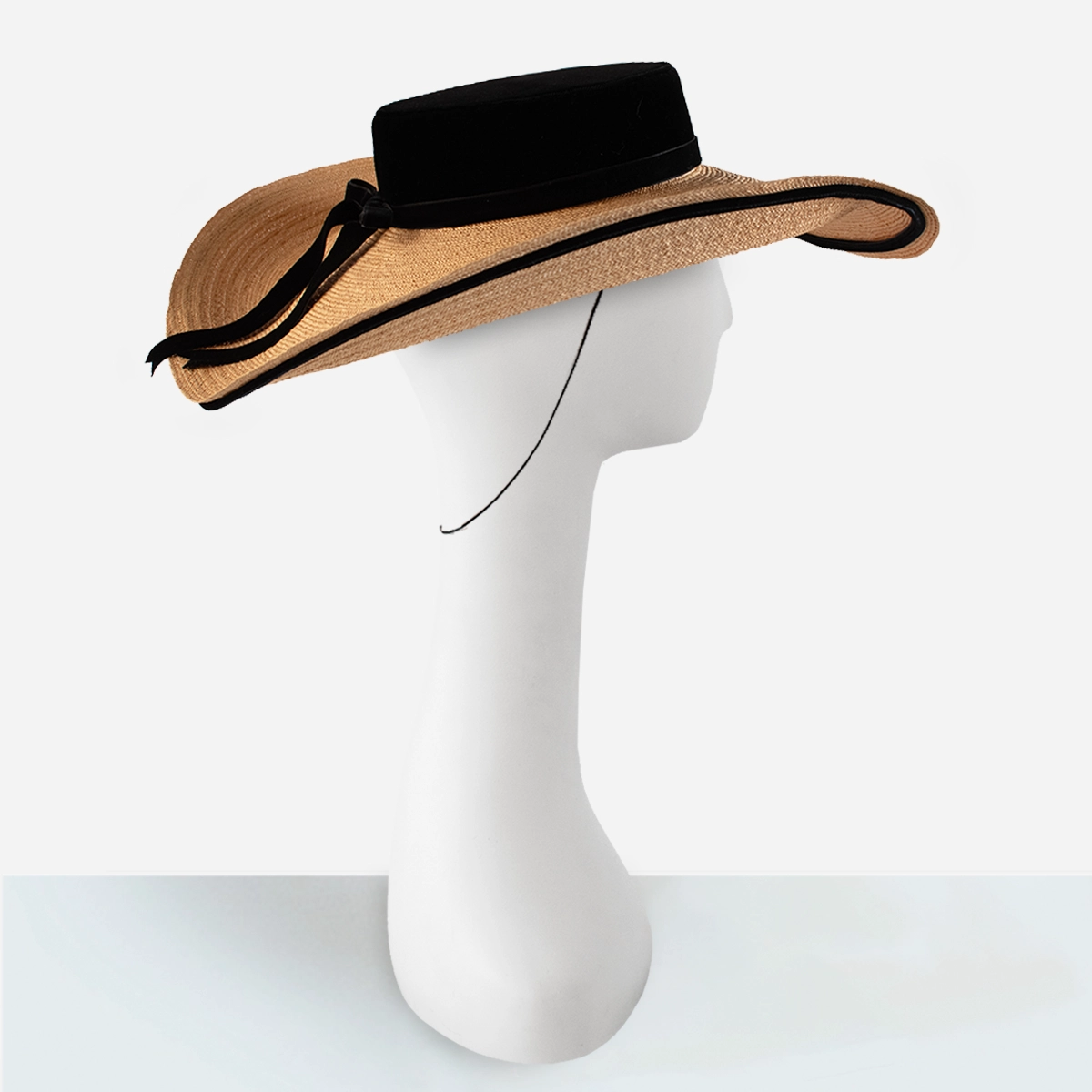Side view of vintage straw cartwheel hat with black velvet trim and wide brim