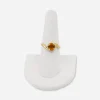 Vintage 14K gold ring displayed on stand, topaz-colored glass center stone.