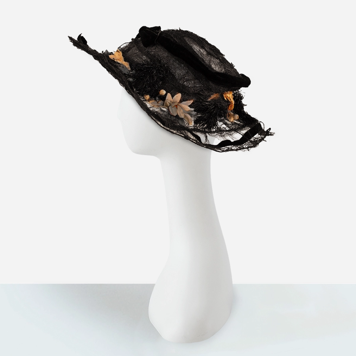 Side view of Edwardian picture hat showing wired brim and floral accents.
