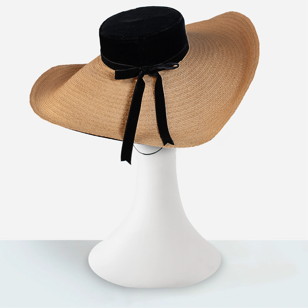 Detail of vintage straw cartwheel hat with black velvet edge trim and woven straw, rear view