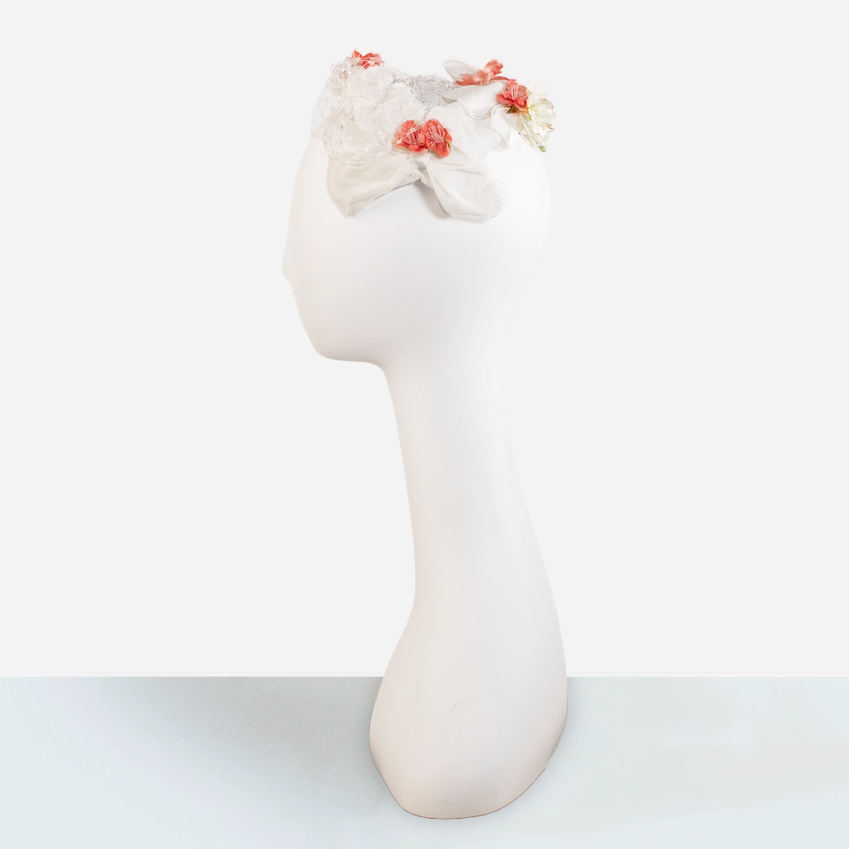 Vintage white openwork half hat worn on mannequin with floral trim