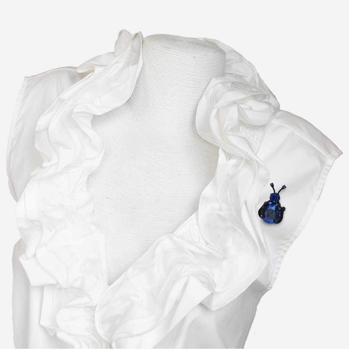 Vintage Warner blue rhinestone bug brooch styled on white ruffle blouse