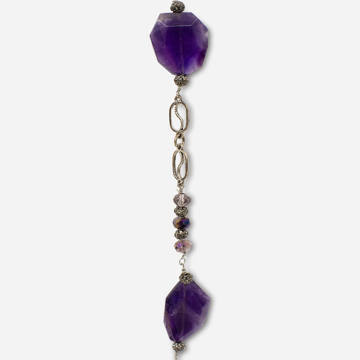 Closeup of long purple faceted glass necklace with decorative silver links and glass bead accents.