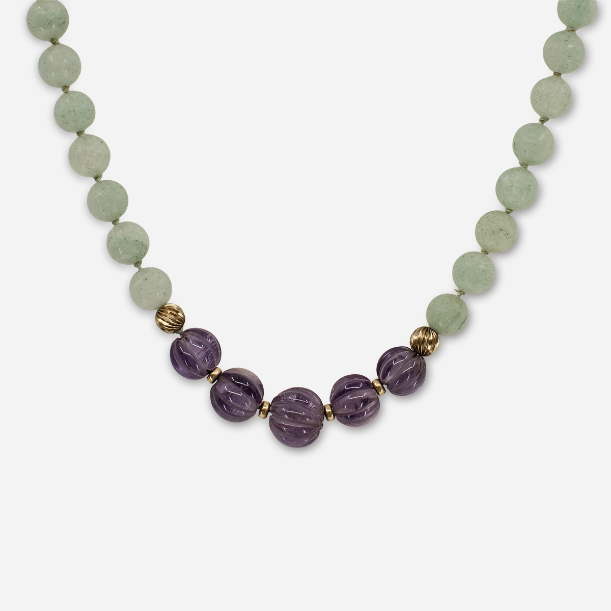 Closeup of 1960s necklace with marbled green aventurine beads, purple glass beads, and brushed gold spacers.