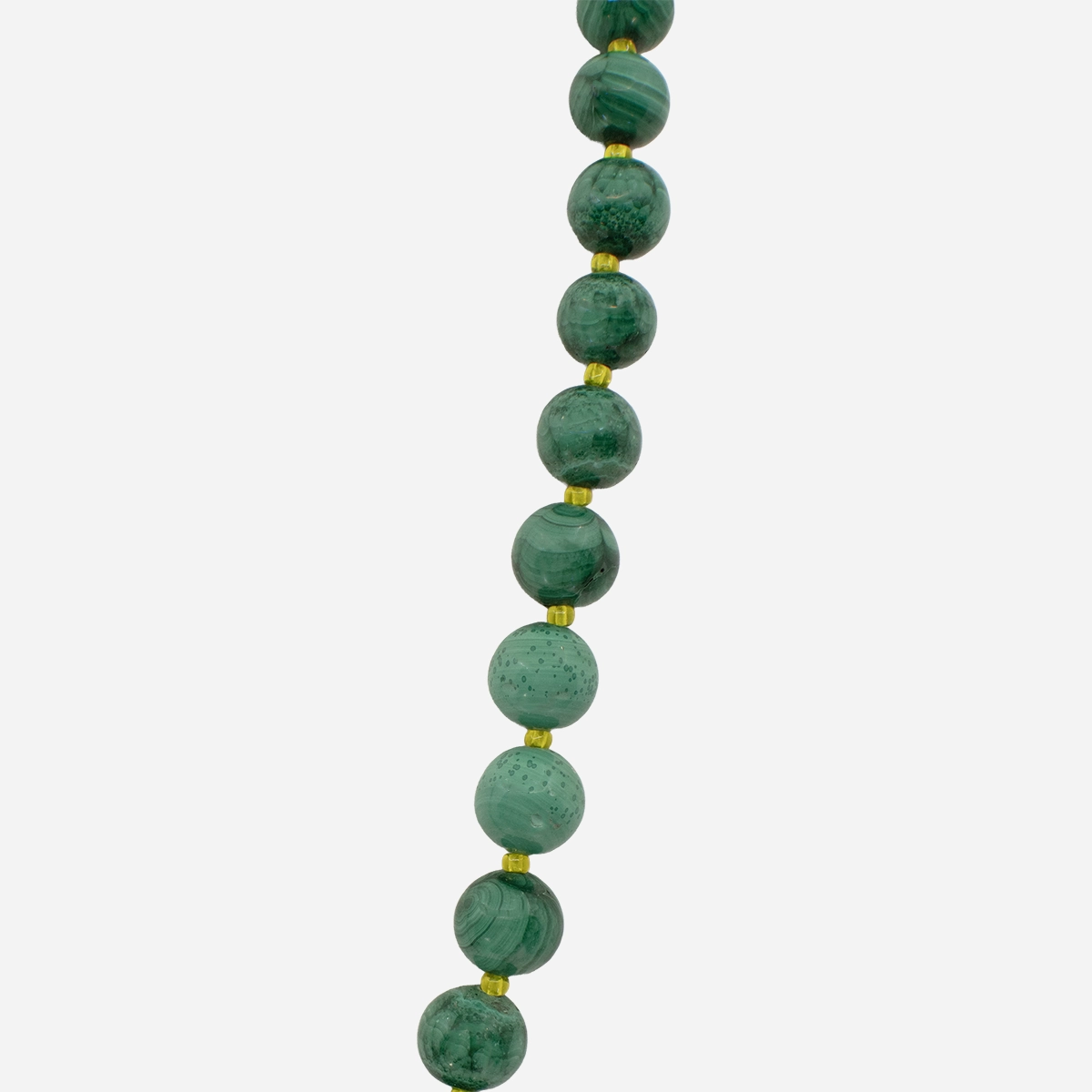 vintage malachite beads Closeup of vintage malachite necklace with varied green stone beads and yellow glass spacers.