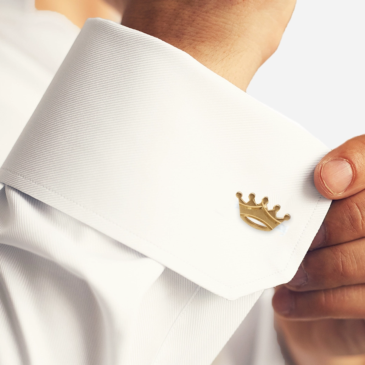Vintage Swank crown cufflink worn on a white shirt cuff, gold-tone novelty men’s accessory.