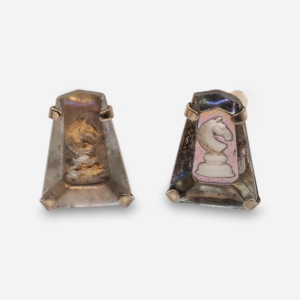 Close-up of smoky lucite-style chess knight cufflinks, one clearer and one faded.