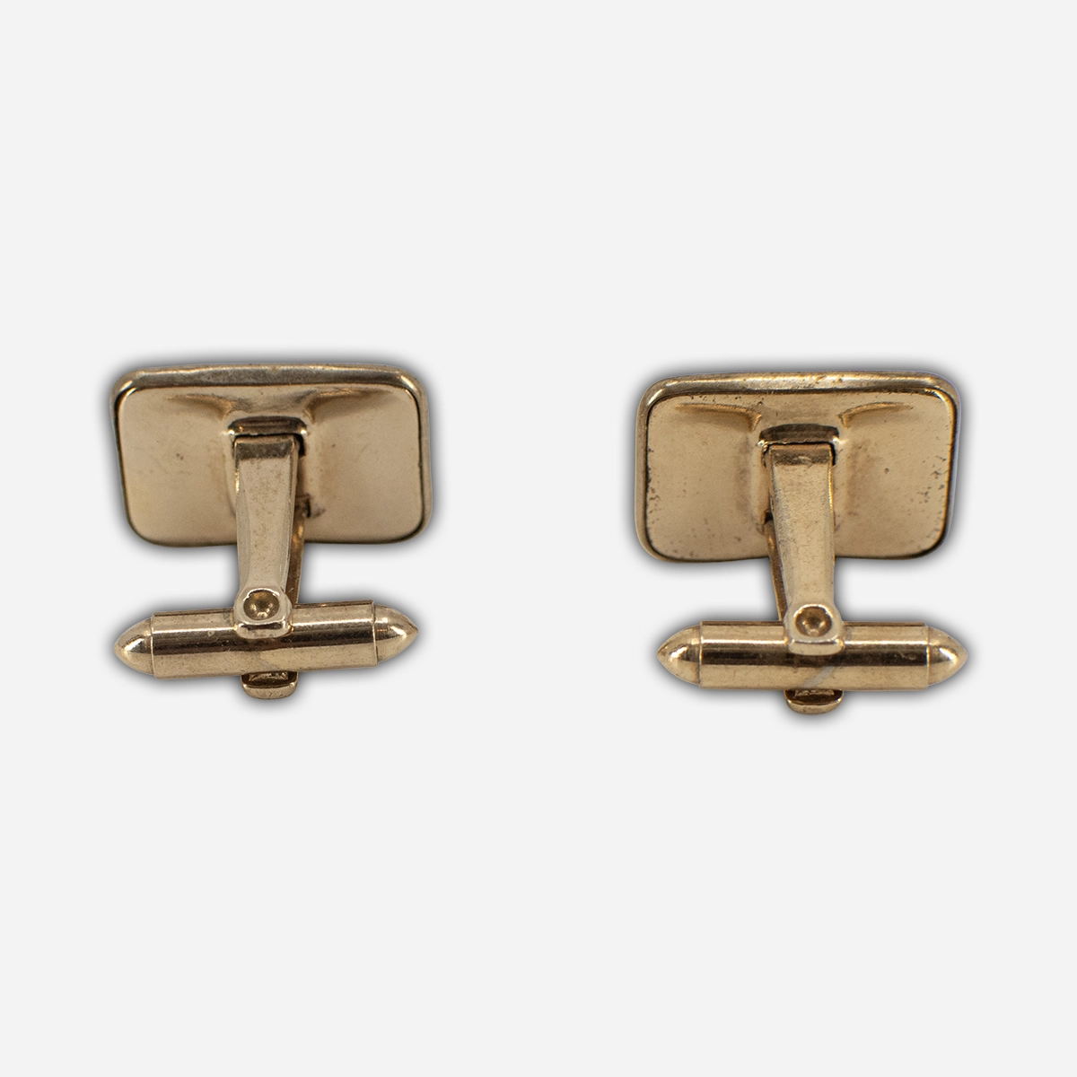 Back view of vintage men’s gold-tone cufflinks with bullet-back torpedo toggle closures.