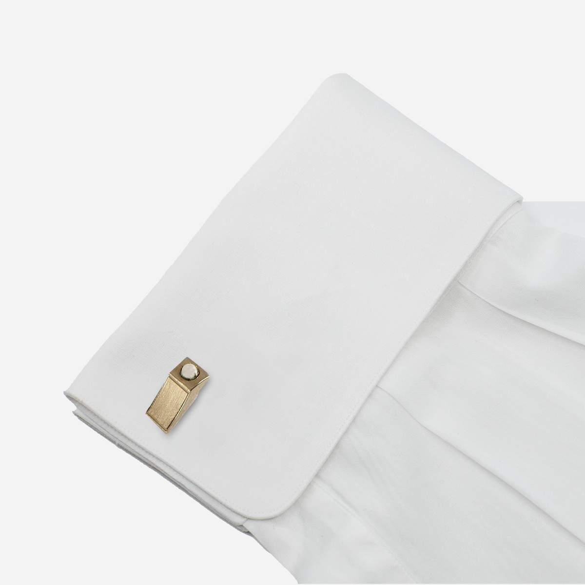 Vintage 1950s goldtone pearl cufflink styled on a white French cuff.