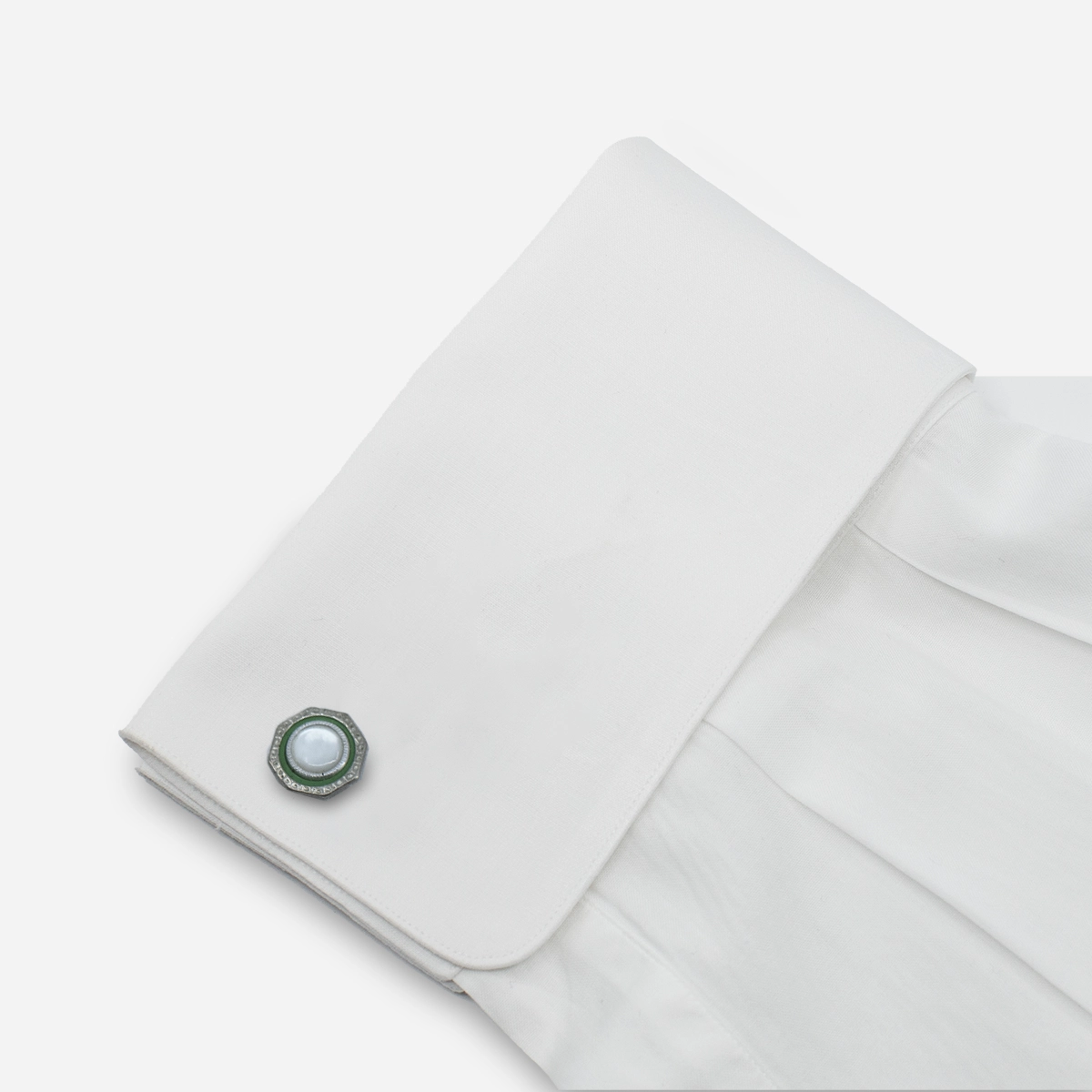 Art Deco cufflink shown on a white French cuff shirt.