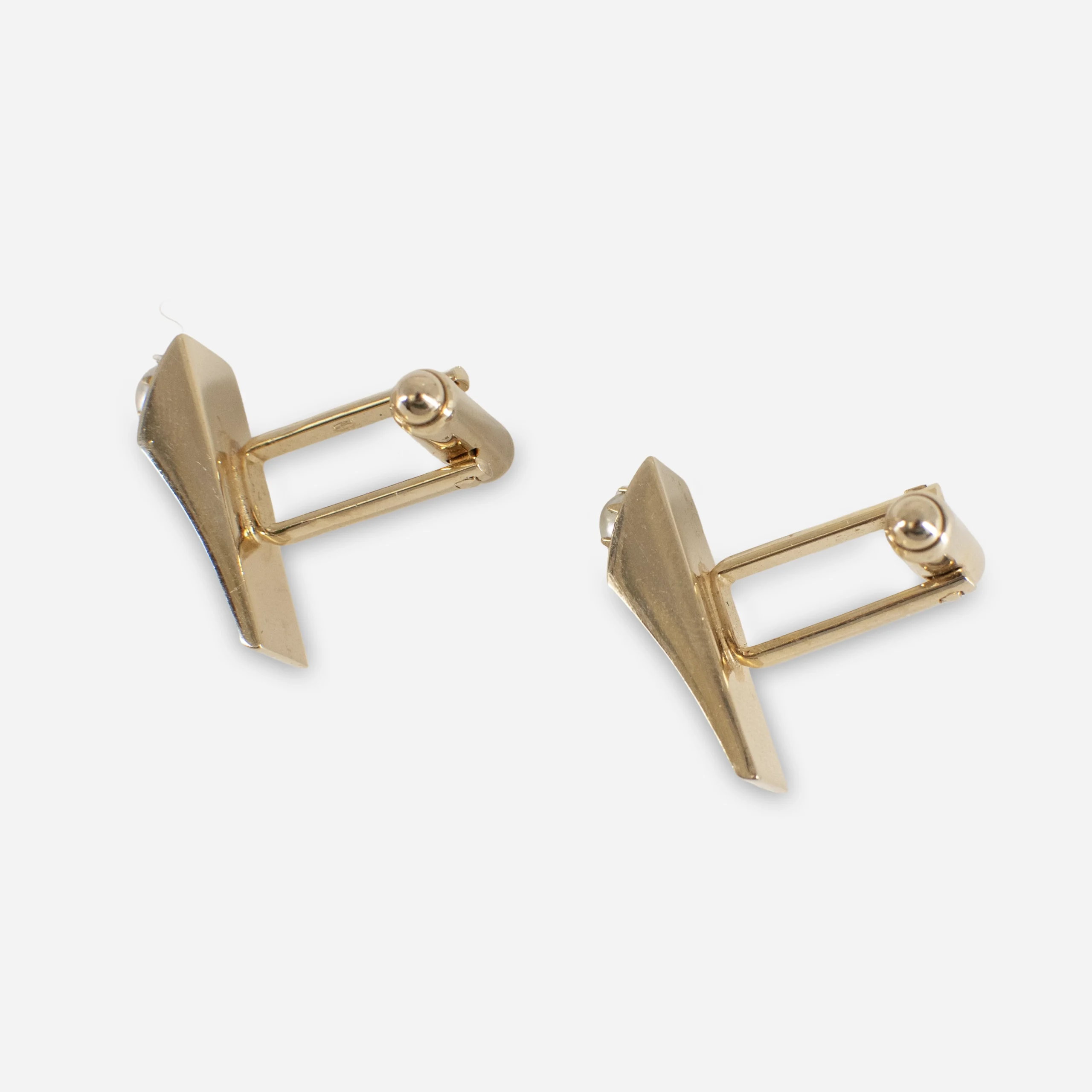 Side view of mid-century goldtone cufflinks showing wedge design and toggle closures.