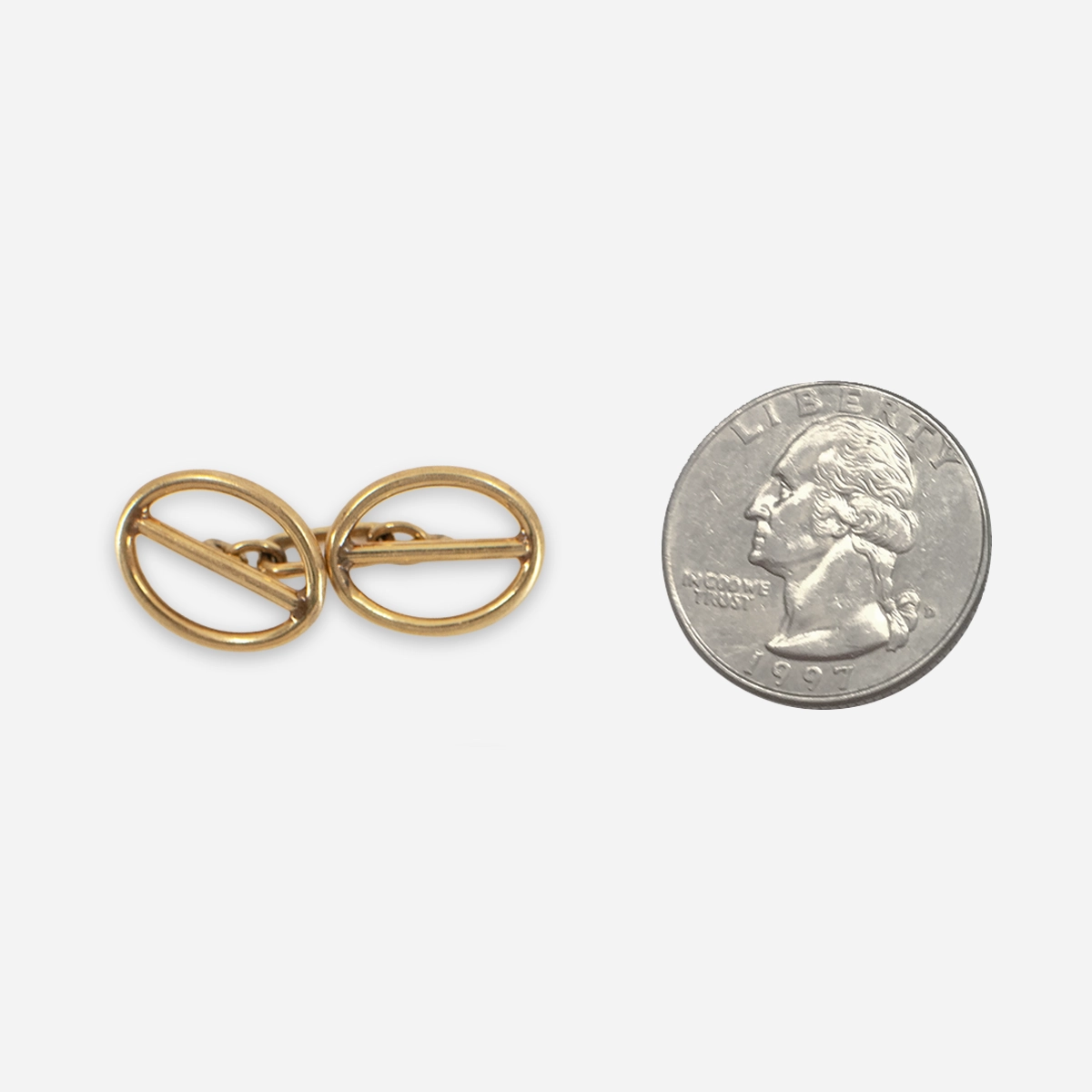 Vintage gold tone oval cufflinks shown beside a quarter for scale.